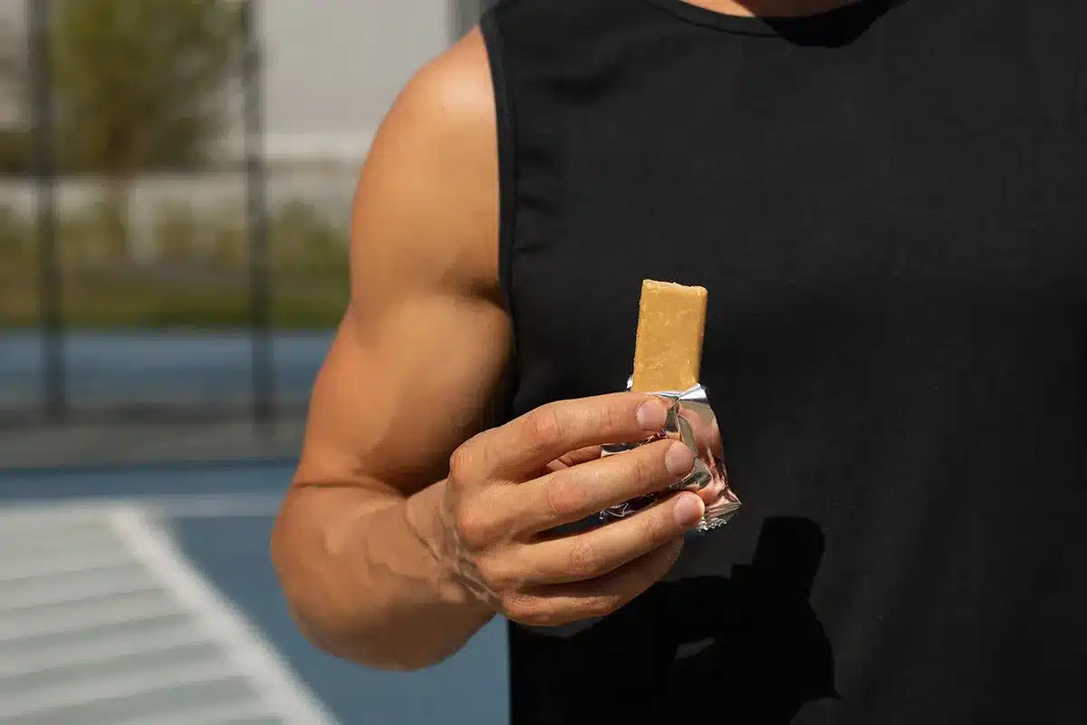 Man holding protein bar.