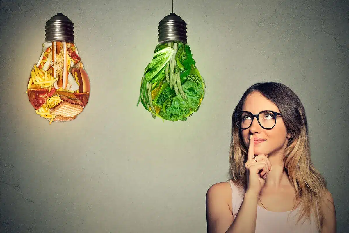 Woman choosing between healthy and unhealthy food options.