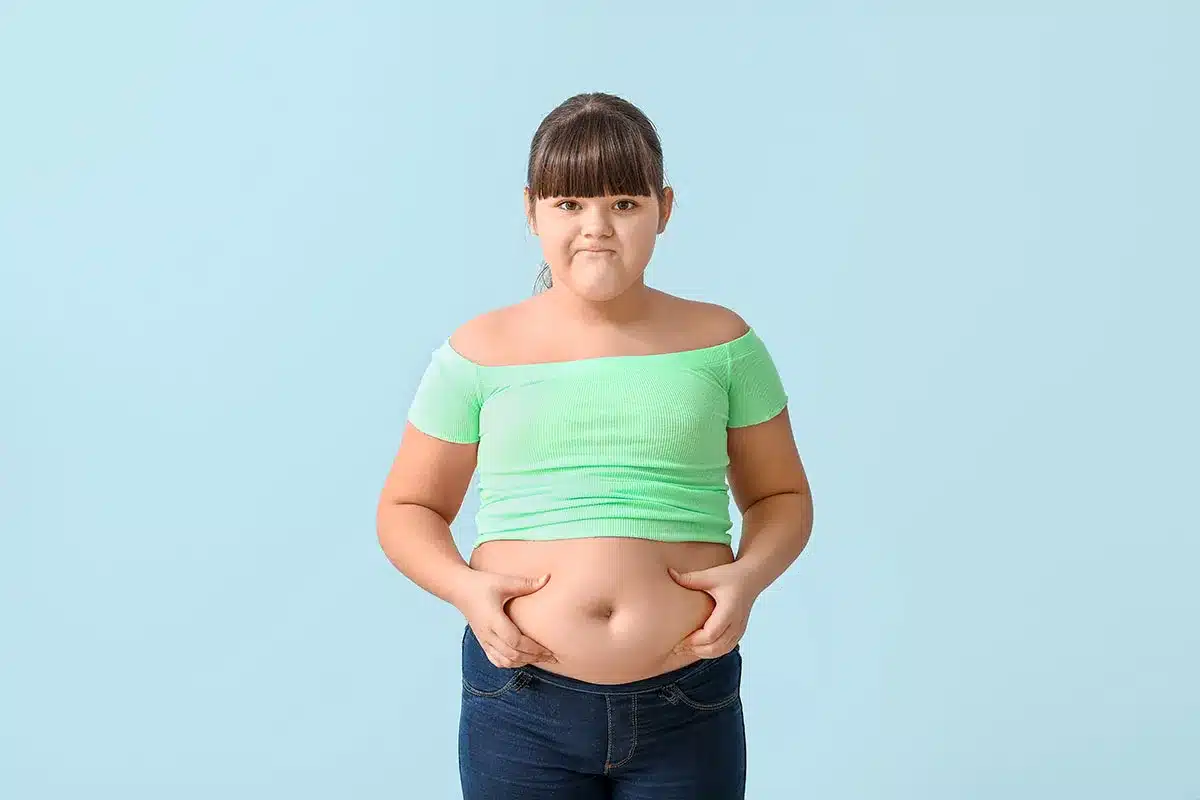 Girl standing against a light blue background.