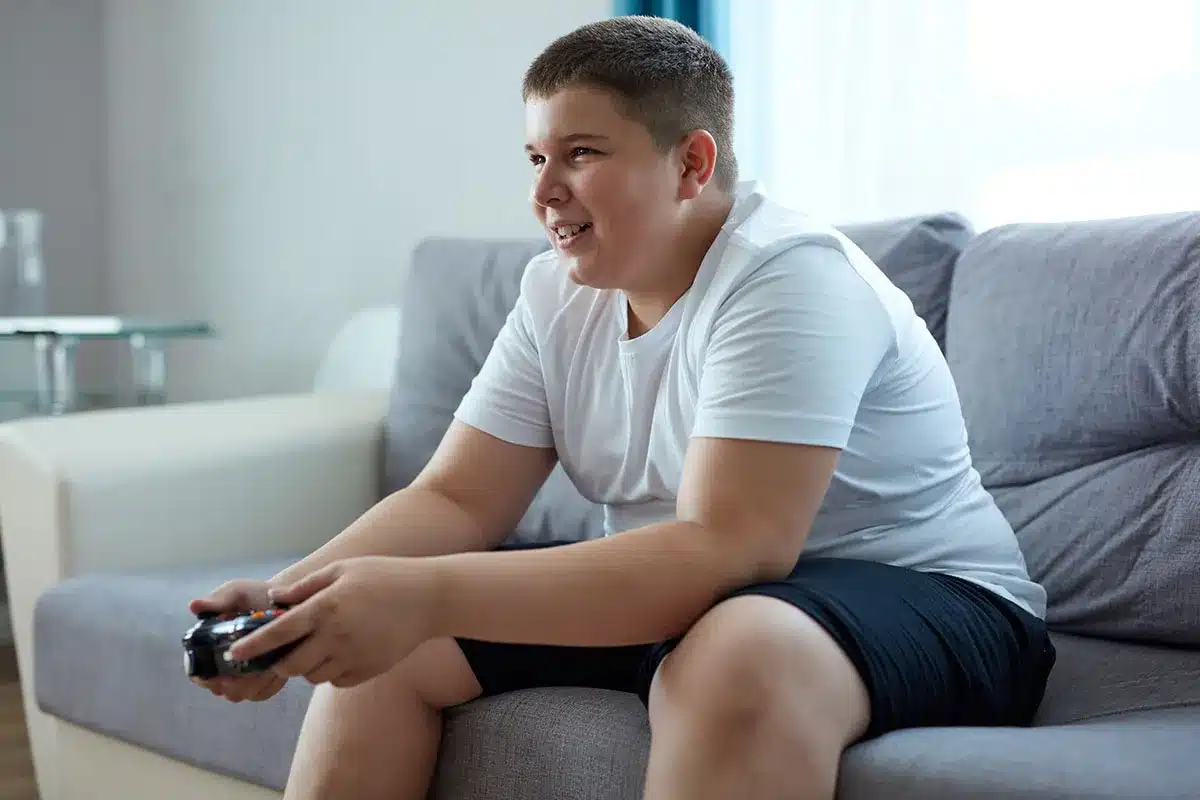 Boy playing video games on couch.