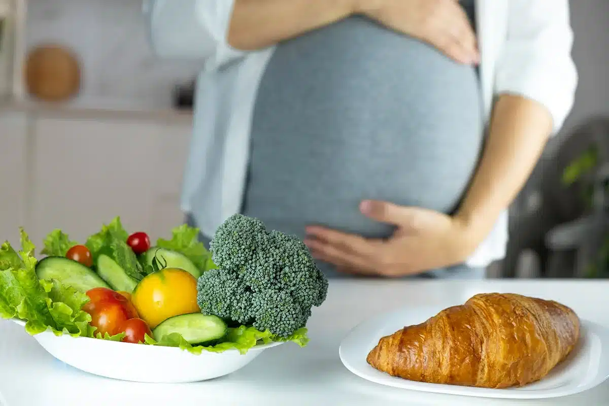 Pregnant woman with healthy and unhealthy food choices.