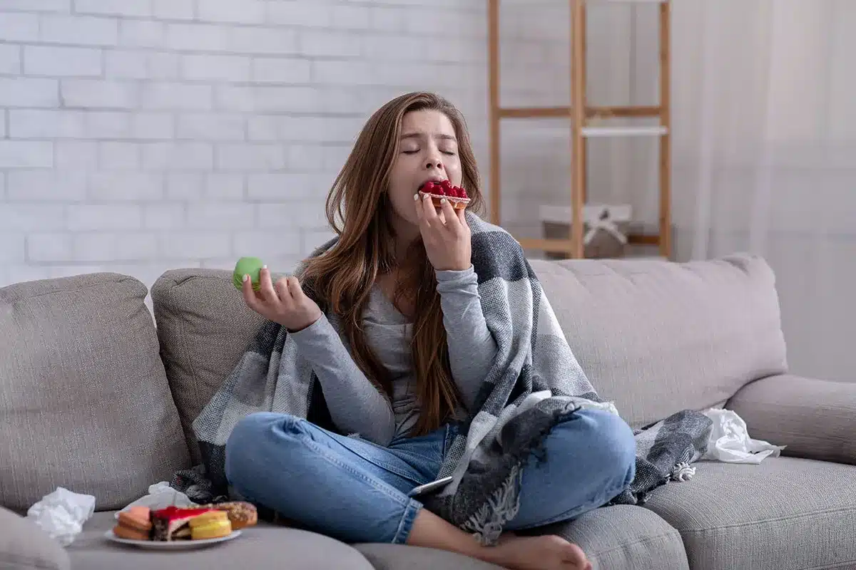 Girl eating dessert on couch.