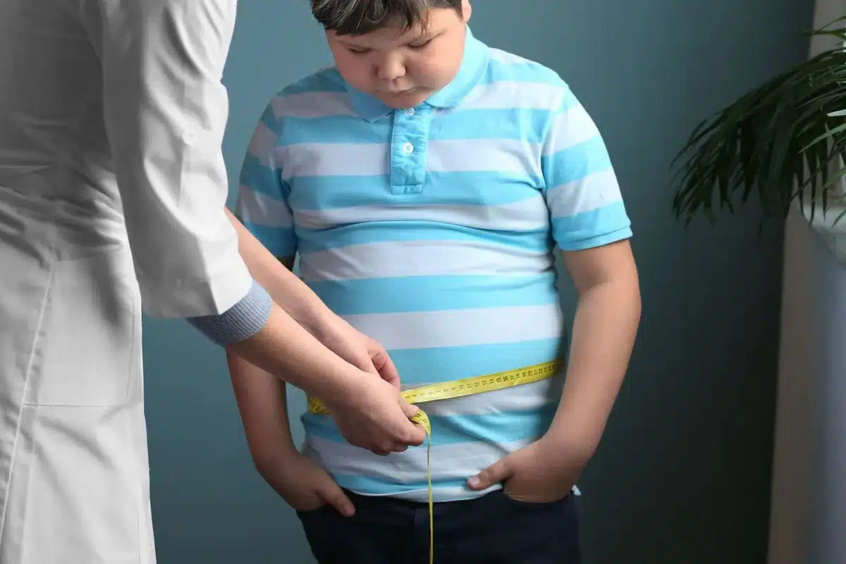 Doctor measuring child's waist circumference.