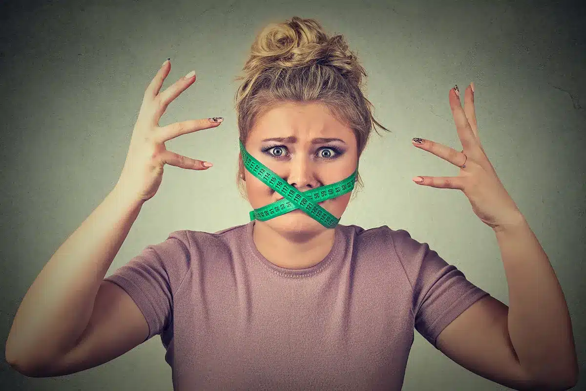 Woman with Measuring Tape Over Mouth