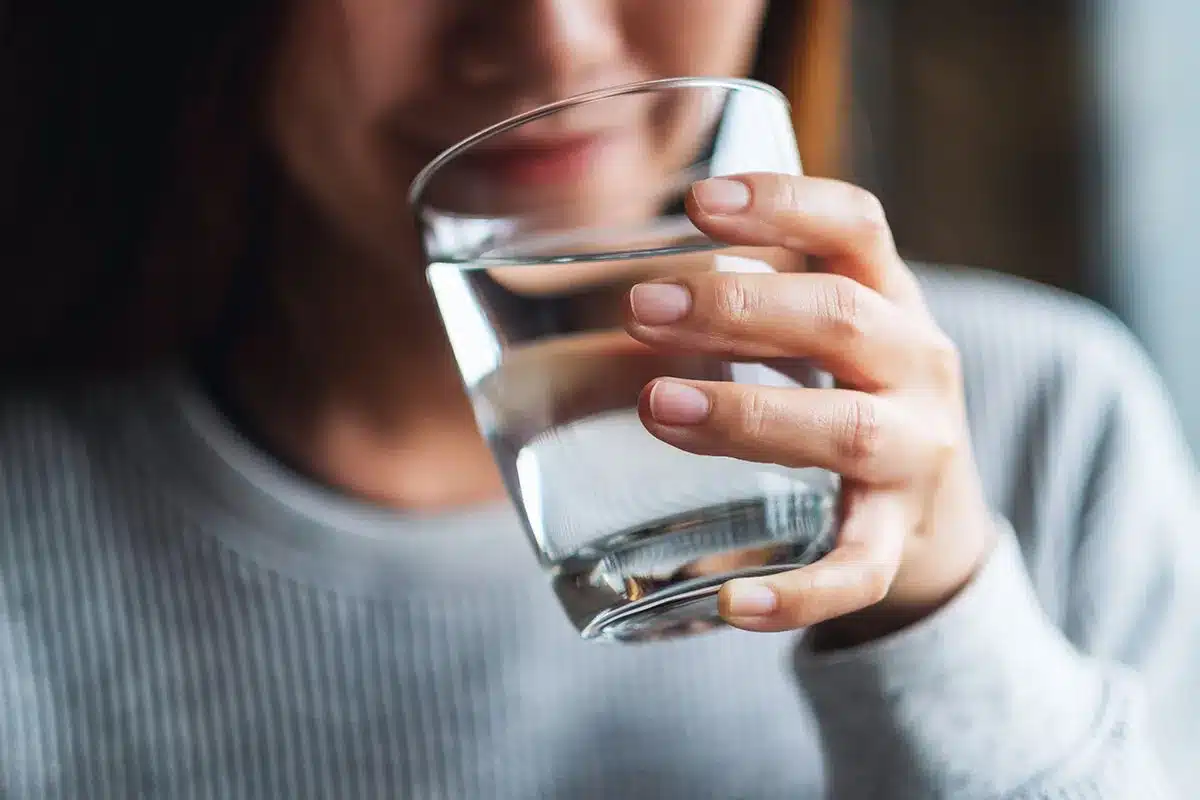 Close-up of a woman drinking a glass of water.