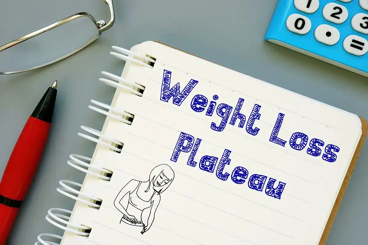 Notebook with weight loss plateau written on it.