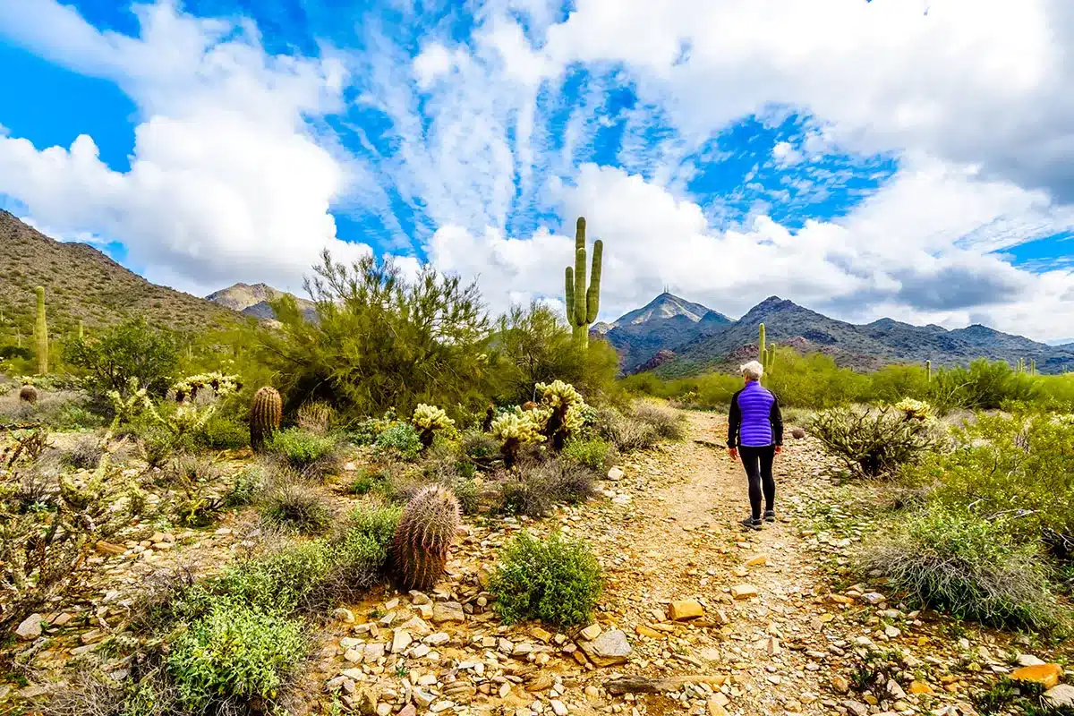 Woman hiking desert trail.