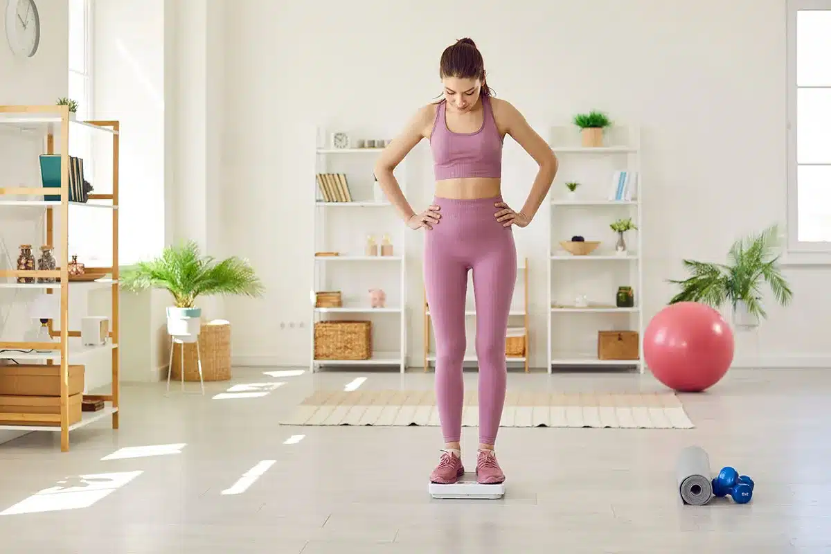 Woman weighing herself.
