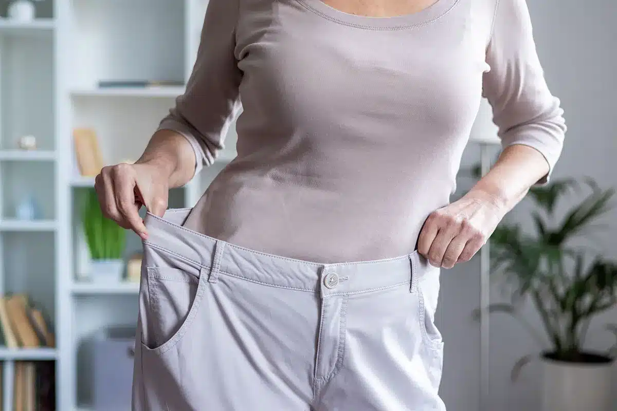 Woman showing weight loss.