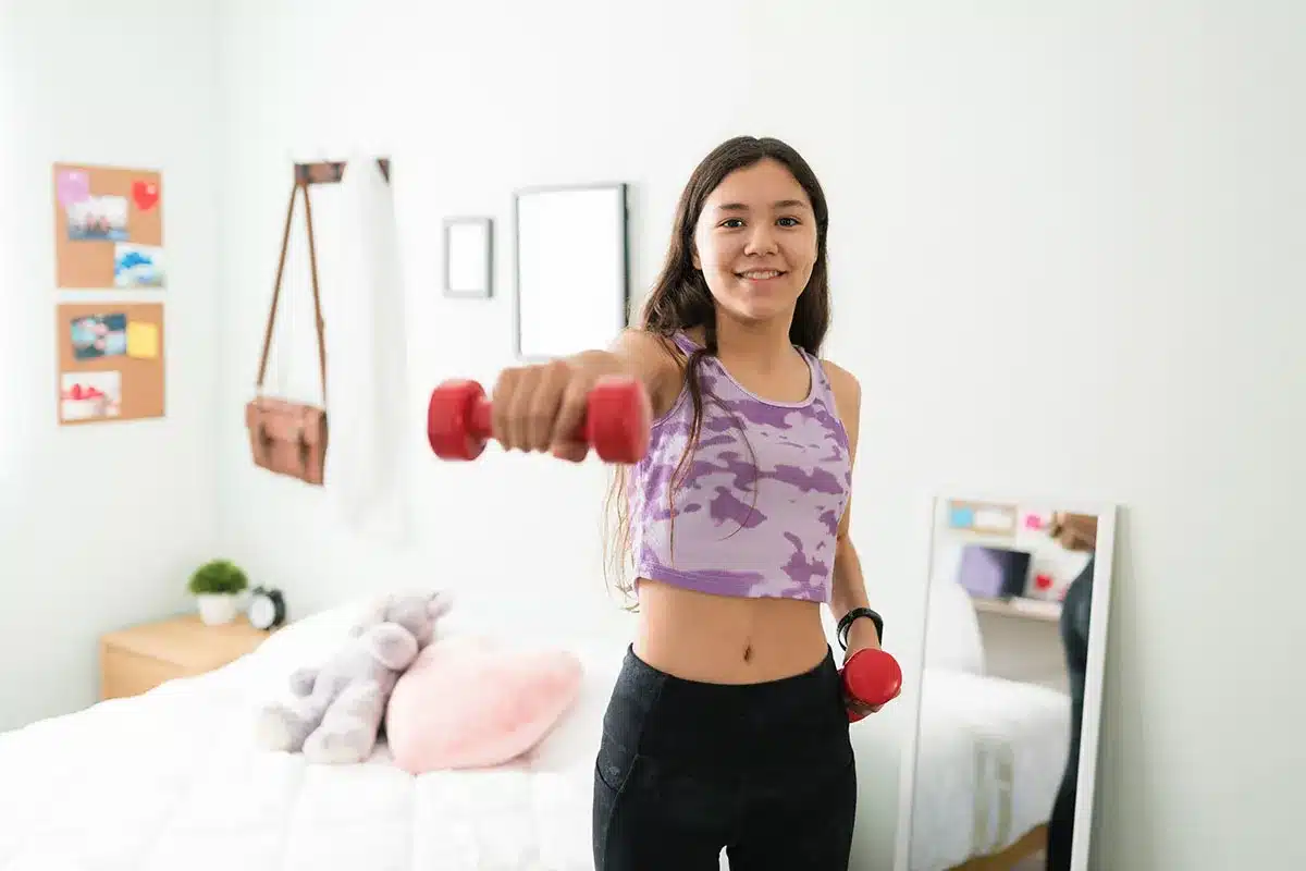 Teen girl weight training.