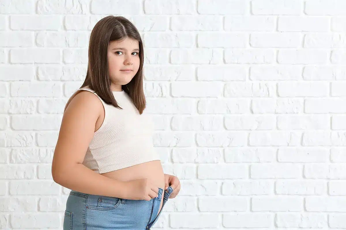 Overweight girl adjusting her jeans.