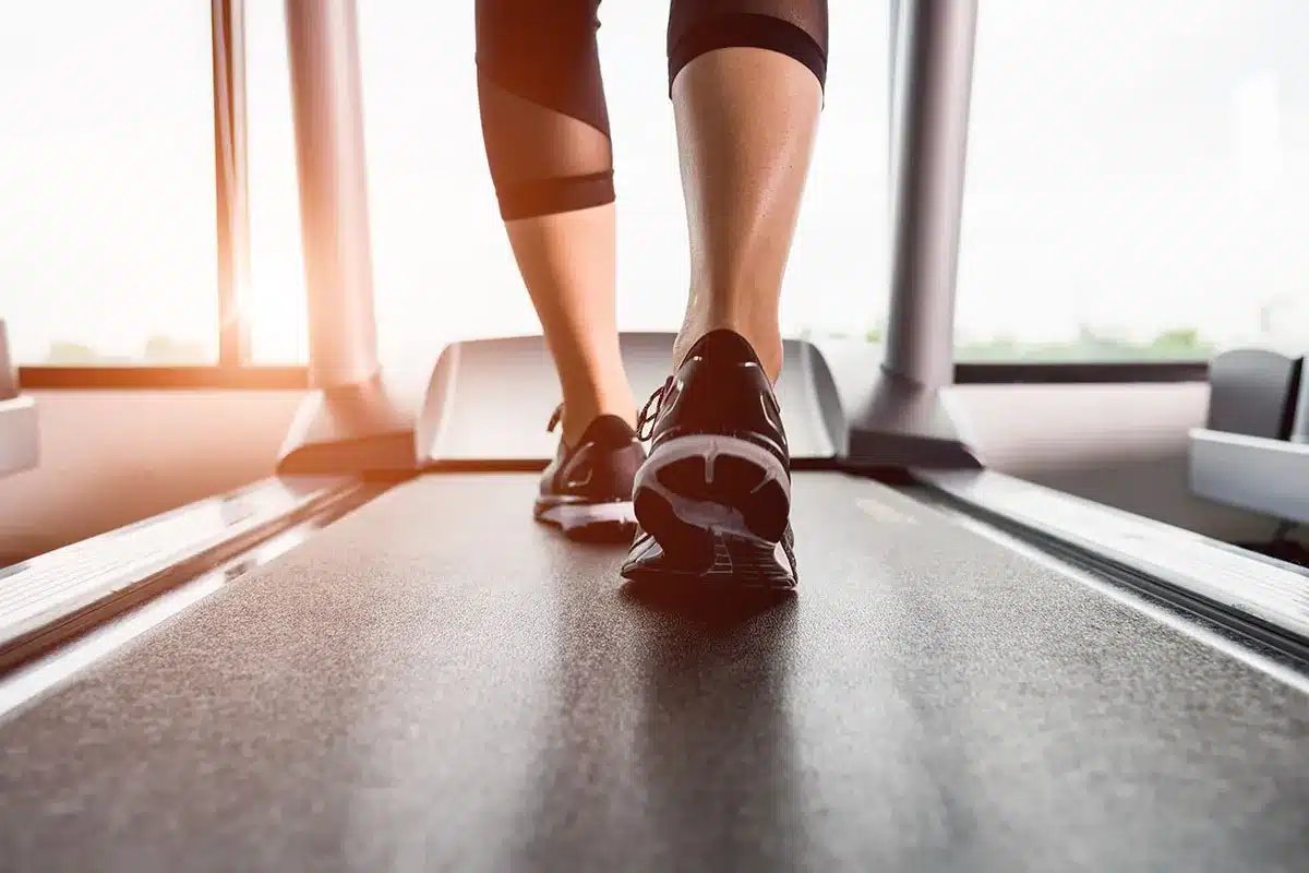 Feet on a treadmill in a gym.