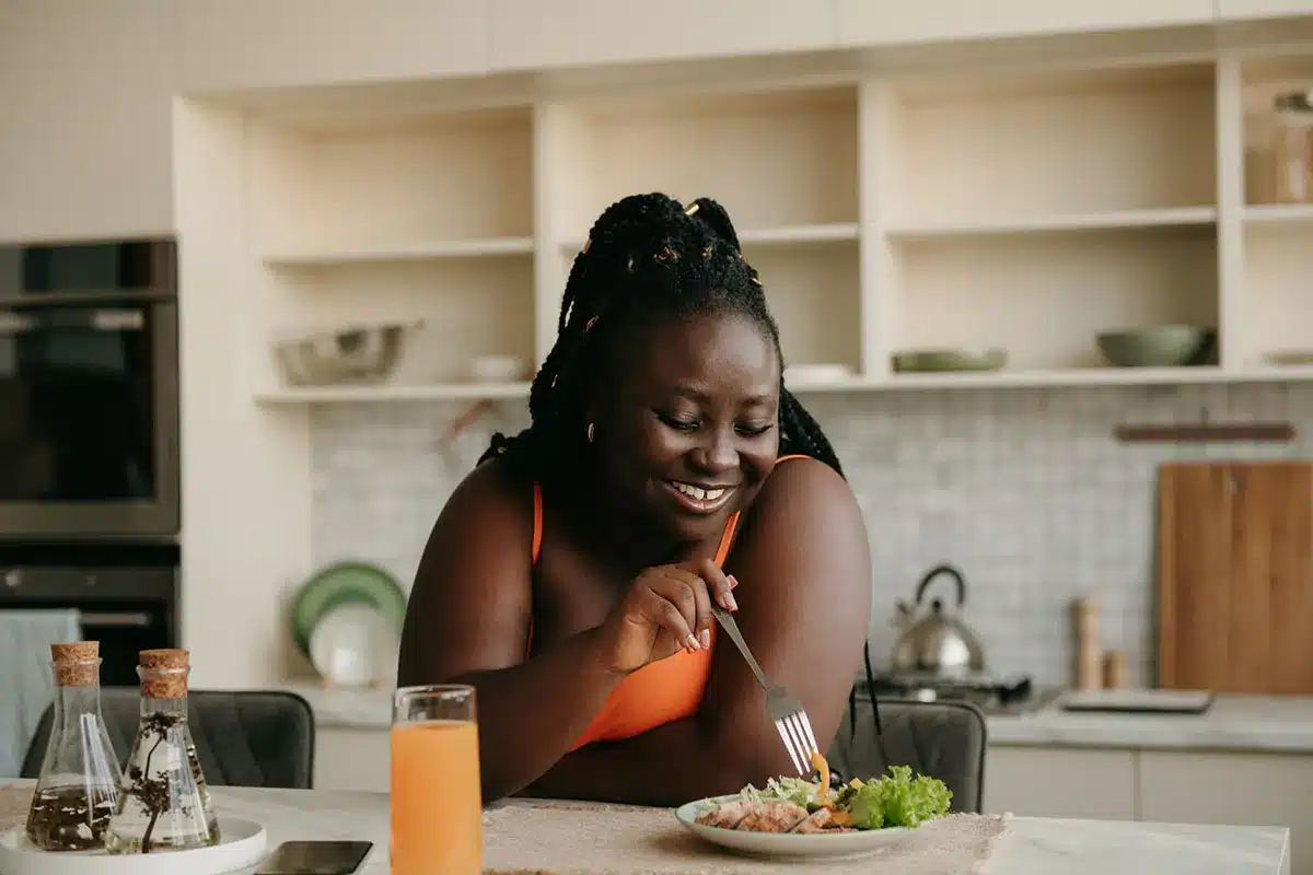 Happy Black woman eating a healthy meal.