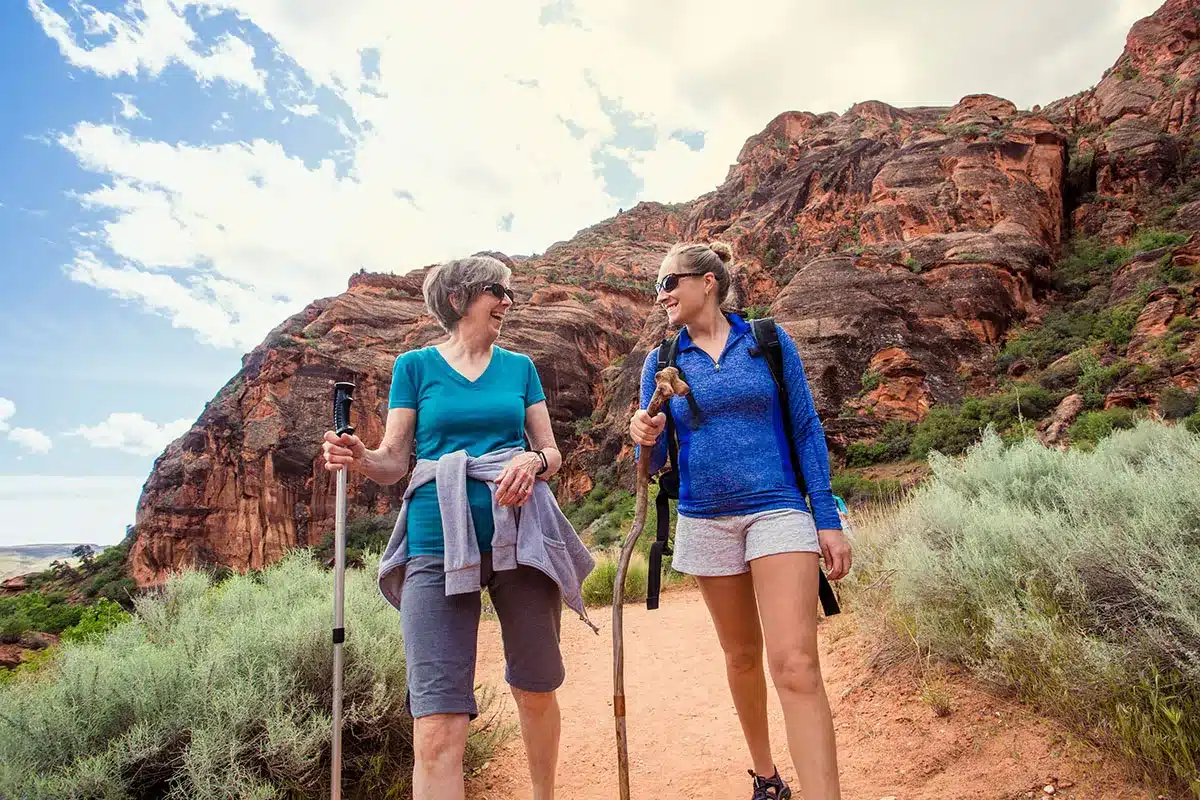 Two women hiking in a desert landscape.