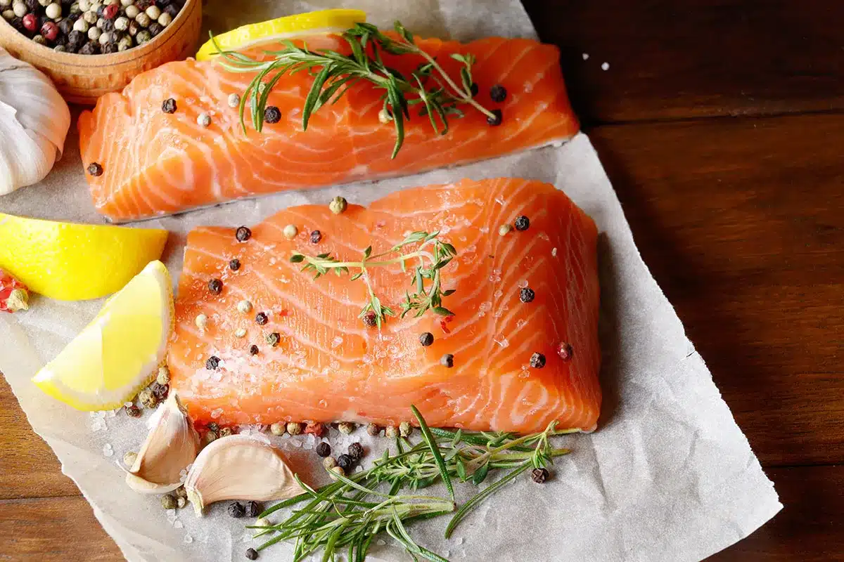Raw salmon fillets with herbs and spices.