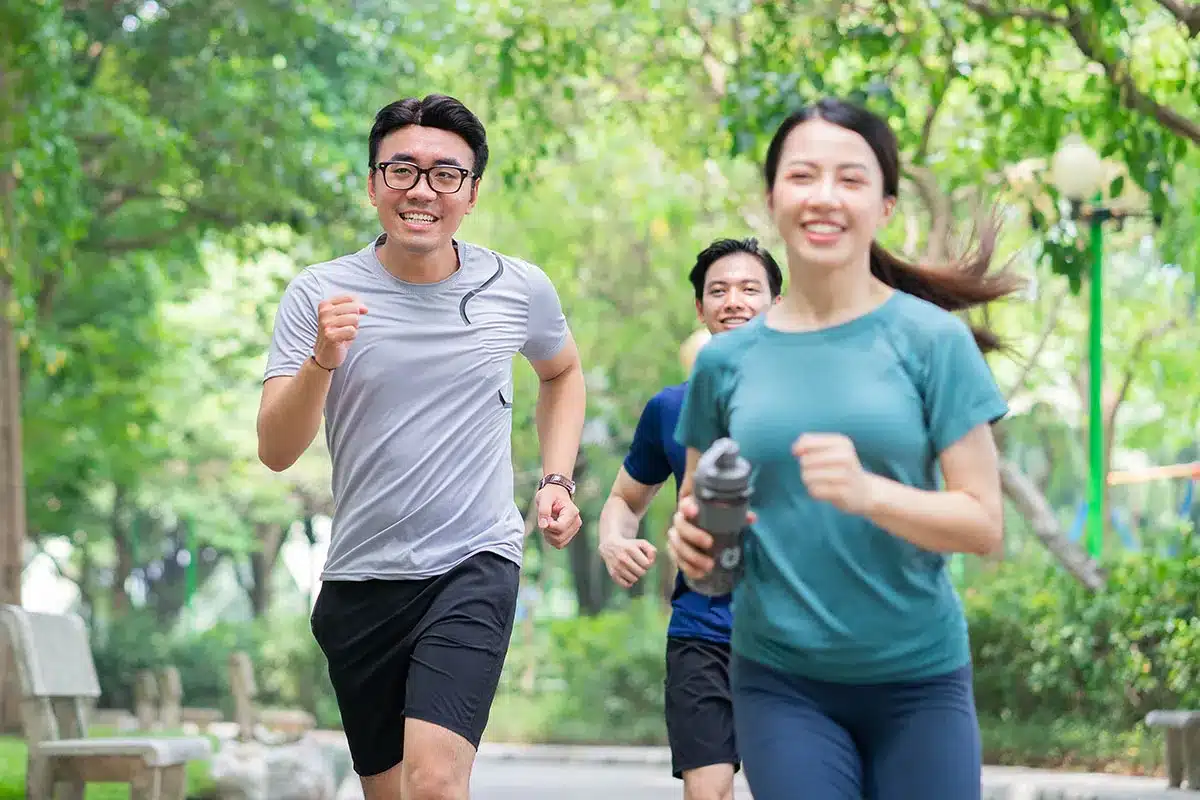 Three people jogging in a park.
