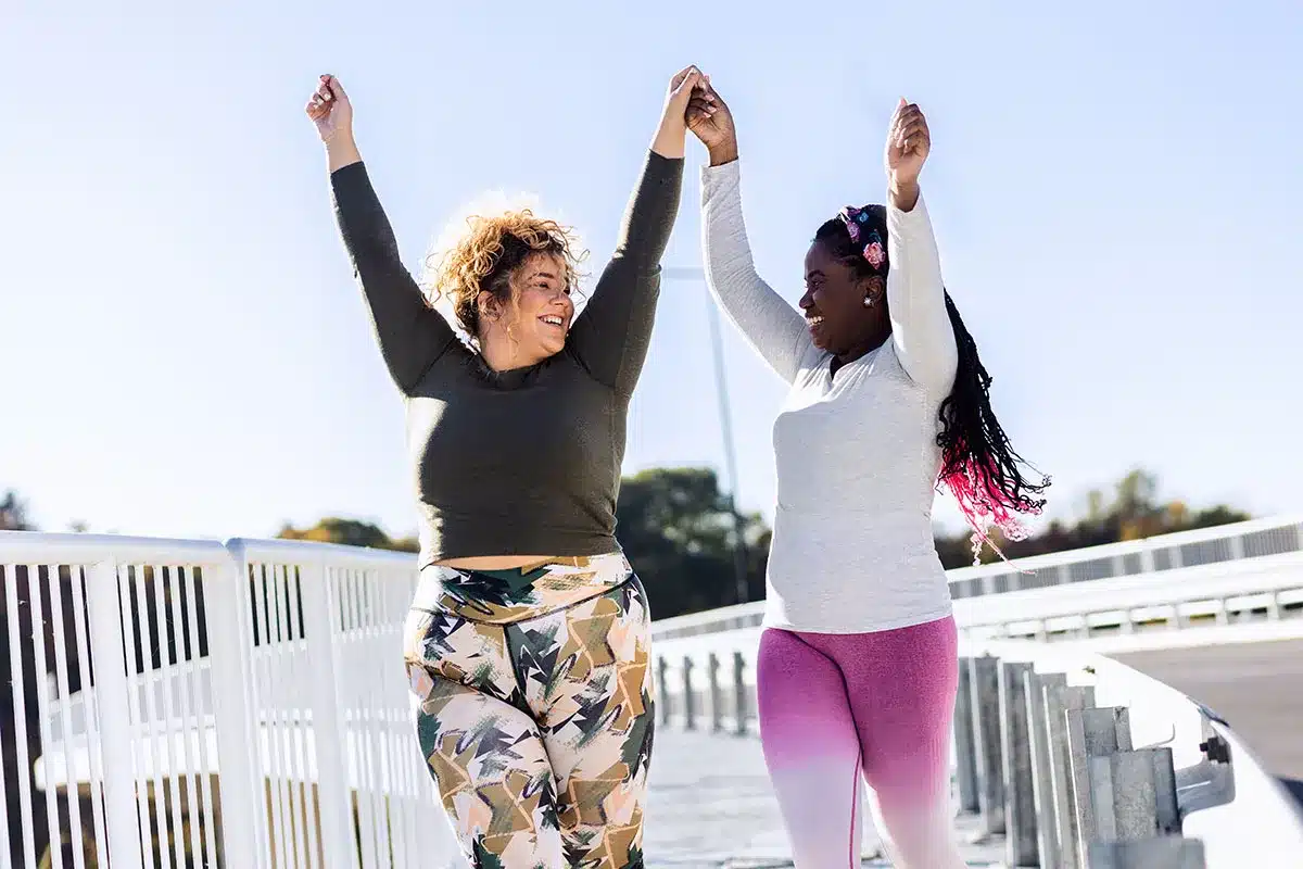 Two plus-size women celebrating after a run.