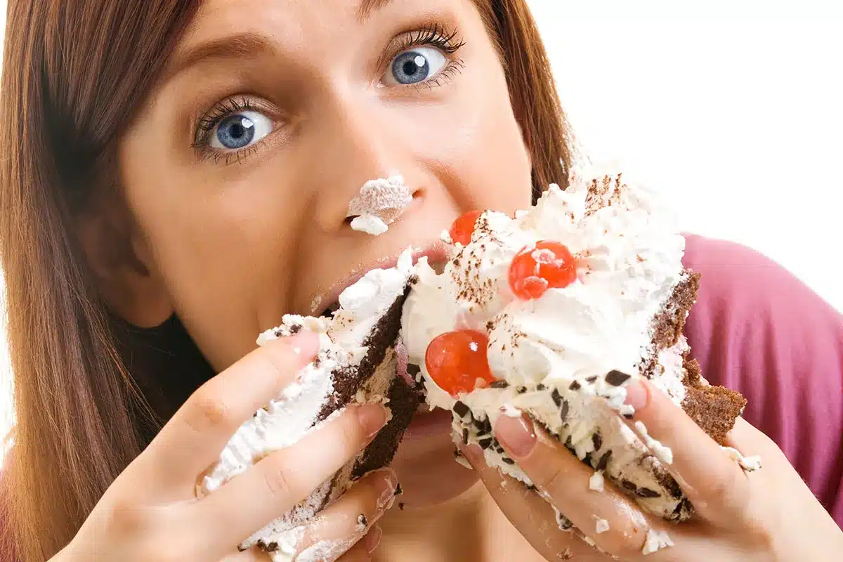 Woman eating a large piece of cake.