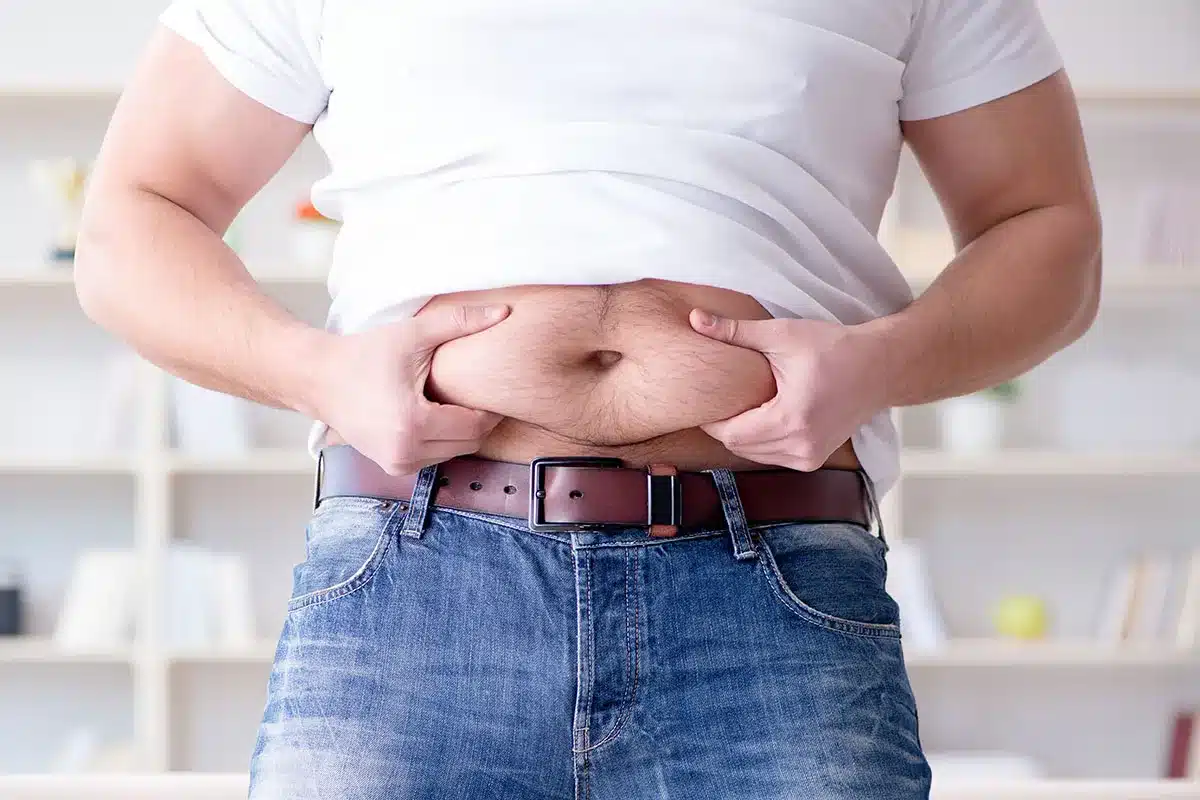 Person holding excess belly fat.
