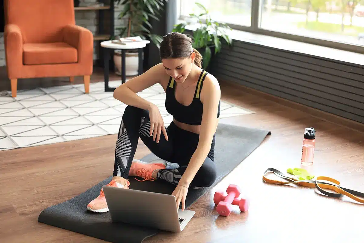 Woman following online fitness class at home.