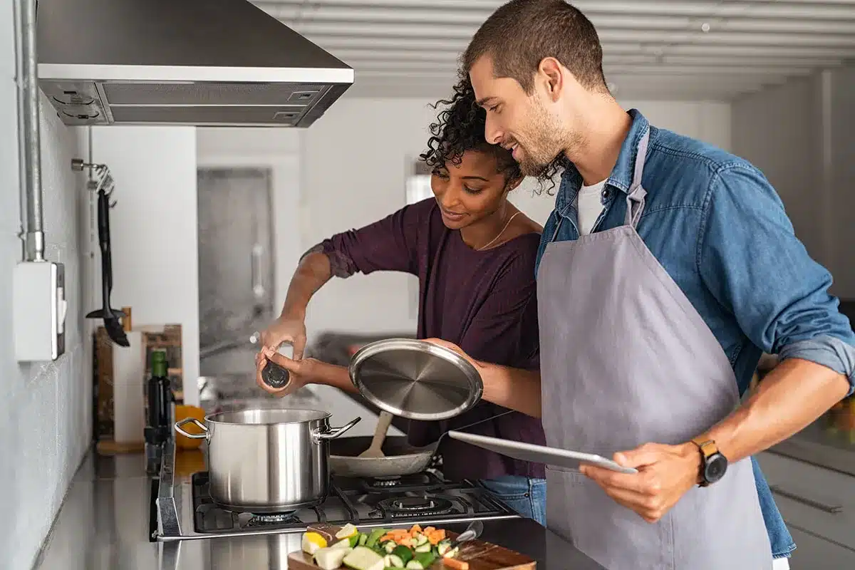 Couple cooking together in kitchen.