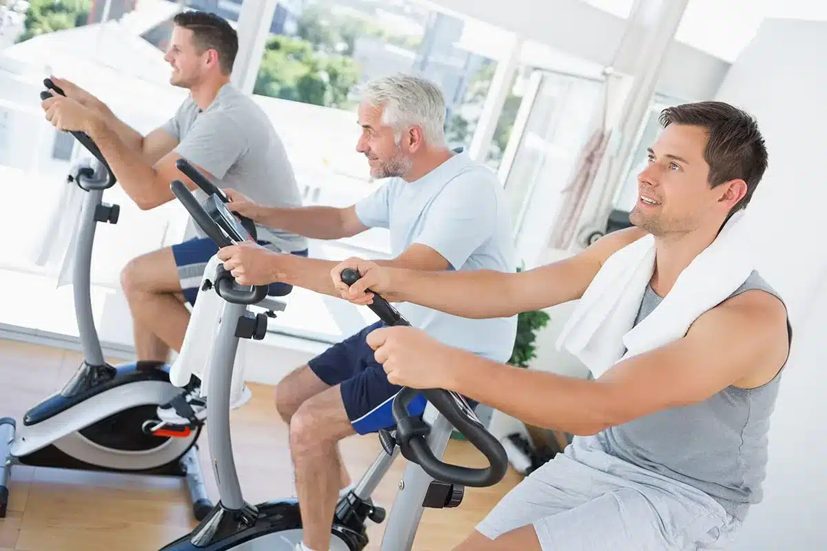 Men exercising on stationary bikes.
