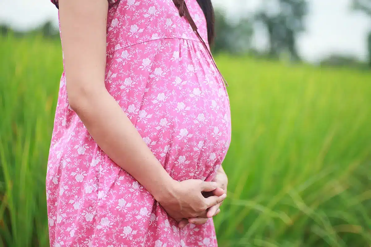 Pregnant woman in pink floral dress.