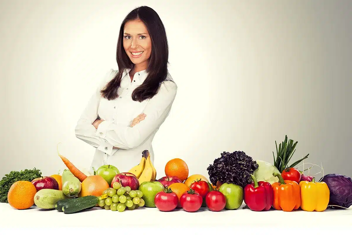 Woman with a variety of fresh fruits and vegetables.