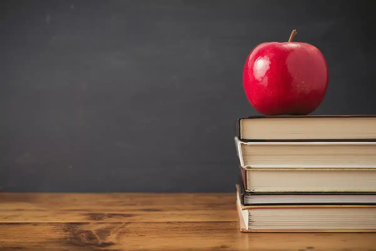 Red apple on stack of books.