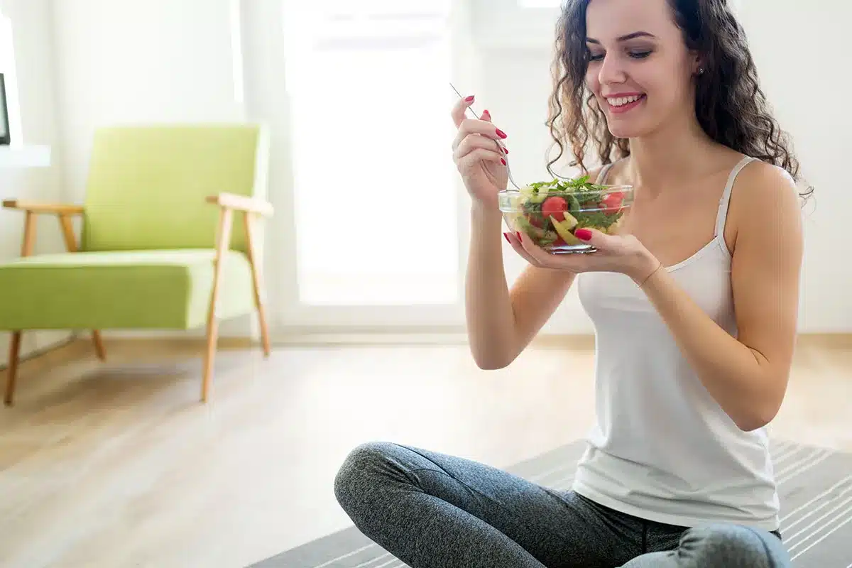 Woman eating healthy salad at home.