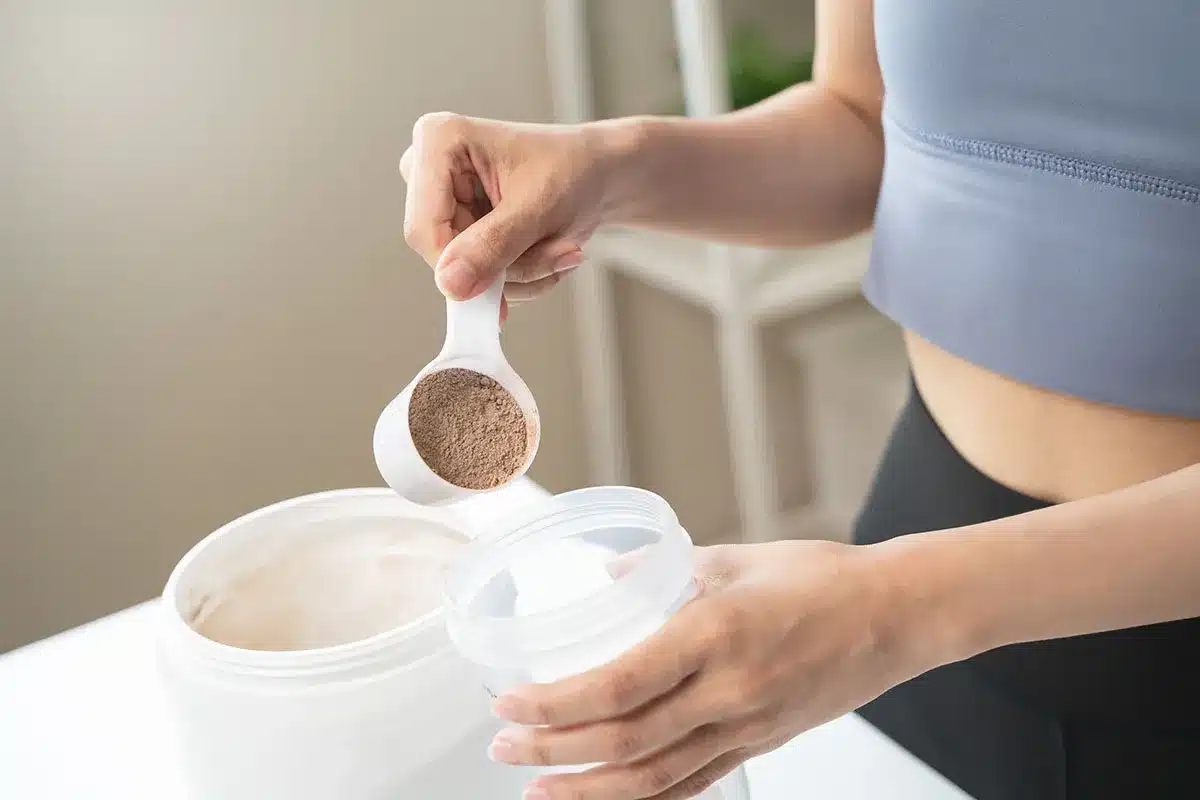 Woman measuring protein powder.