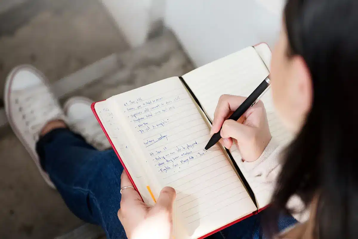 Woman writing notes in a notebook.