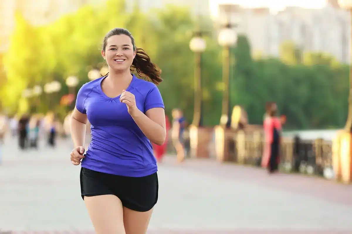 Plus-size woman running outdoors.