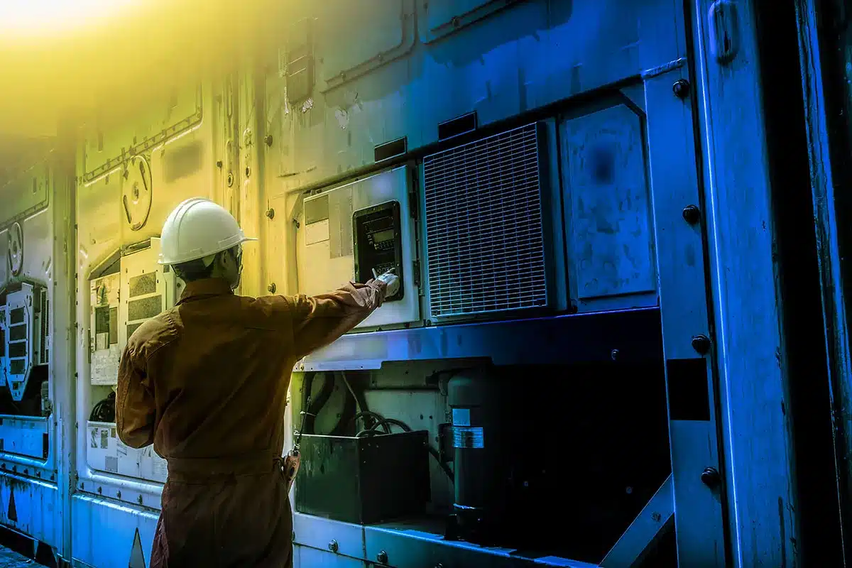 Worker inspecting industrial machinery.