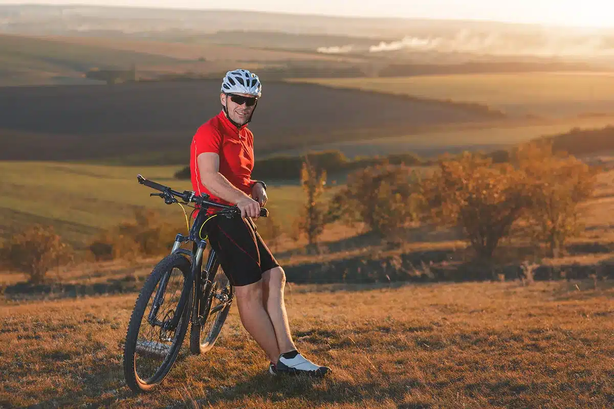 Cyclist resting on mountain bike.