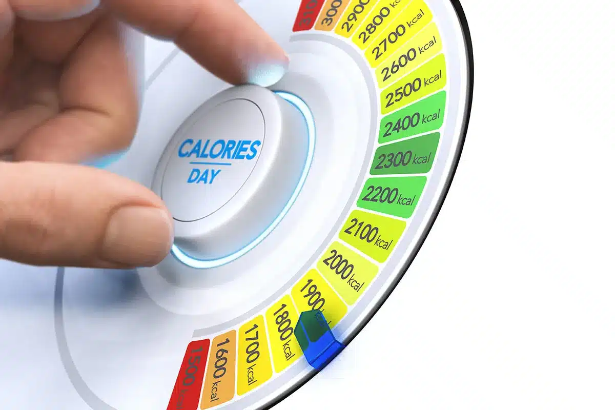 Hand adjusting daily calorie intake dial.