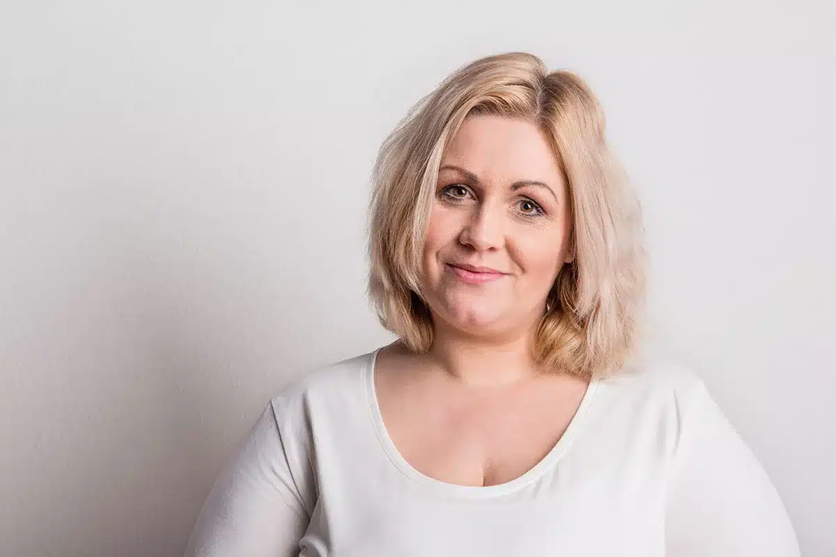 Smiling woman in white shirt.