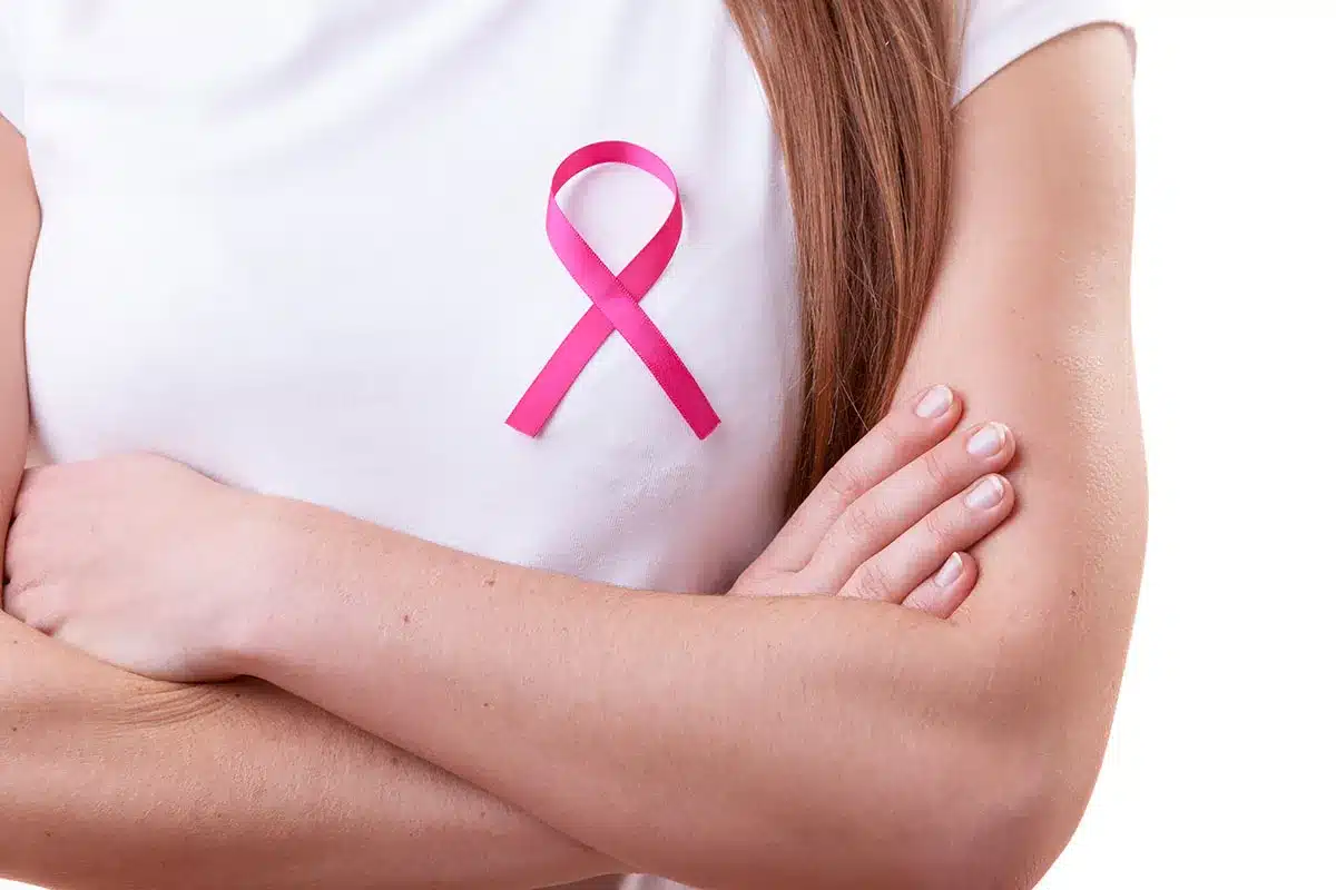 Woman wearing pink ribbon for breast cancer awareness.