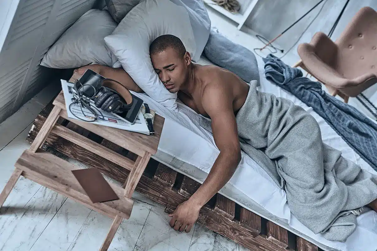 Man sleeping on a pallet bed.