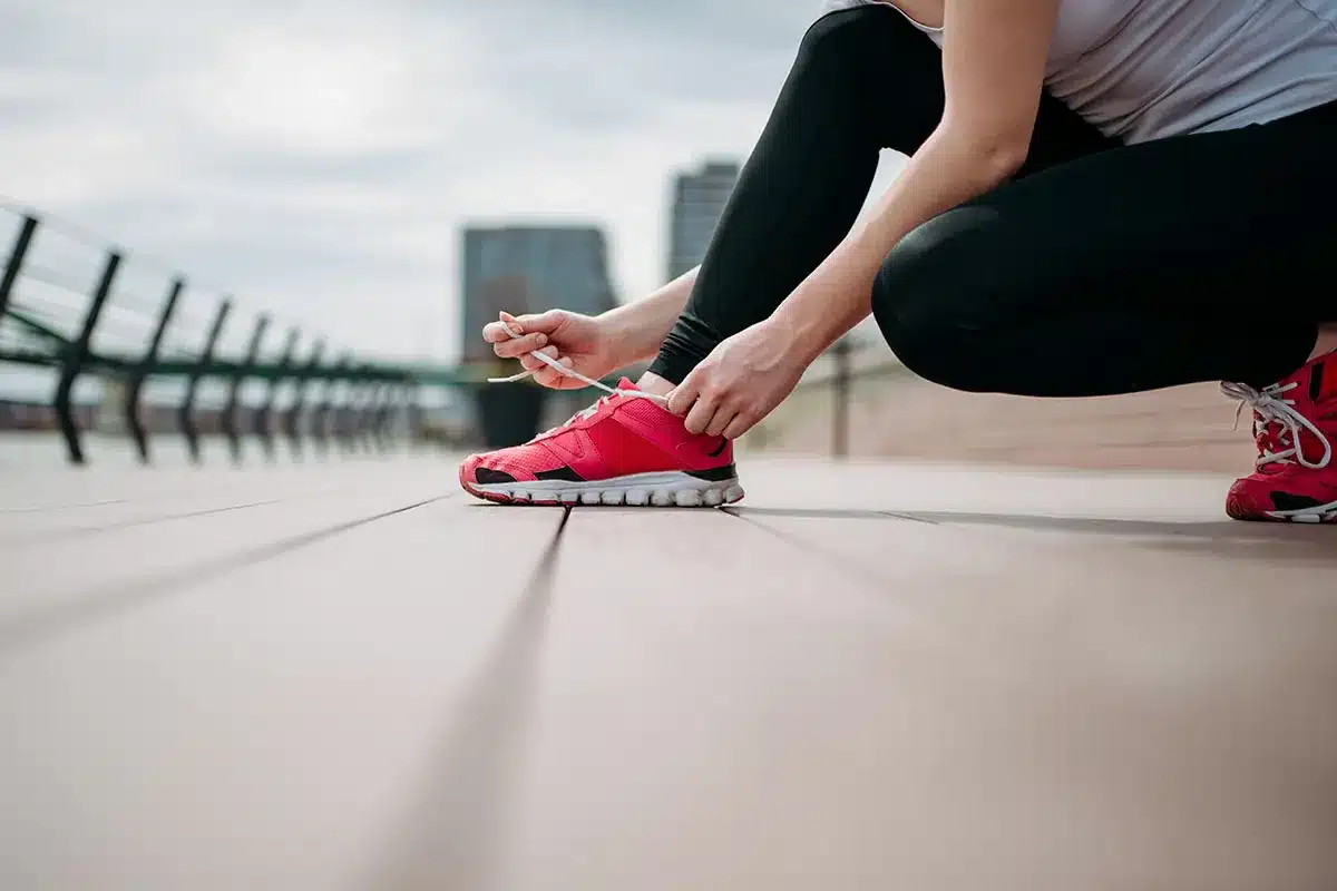Woman tying shoelaces before a run.