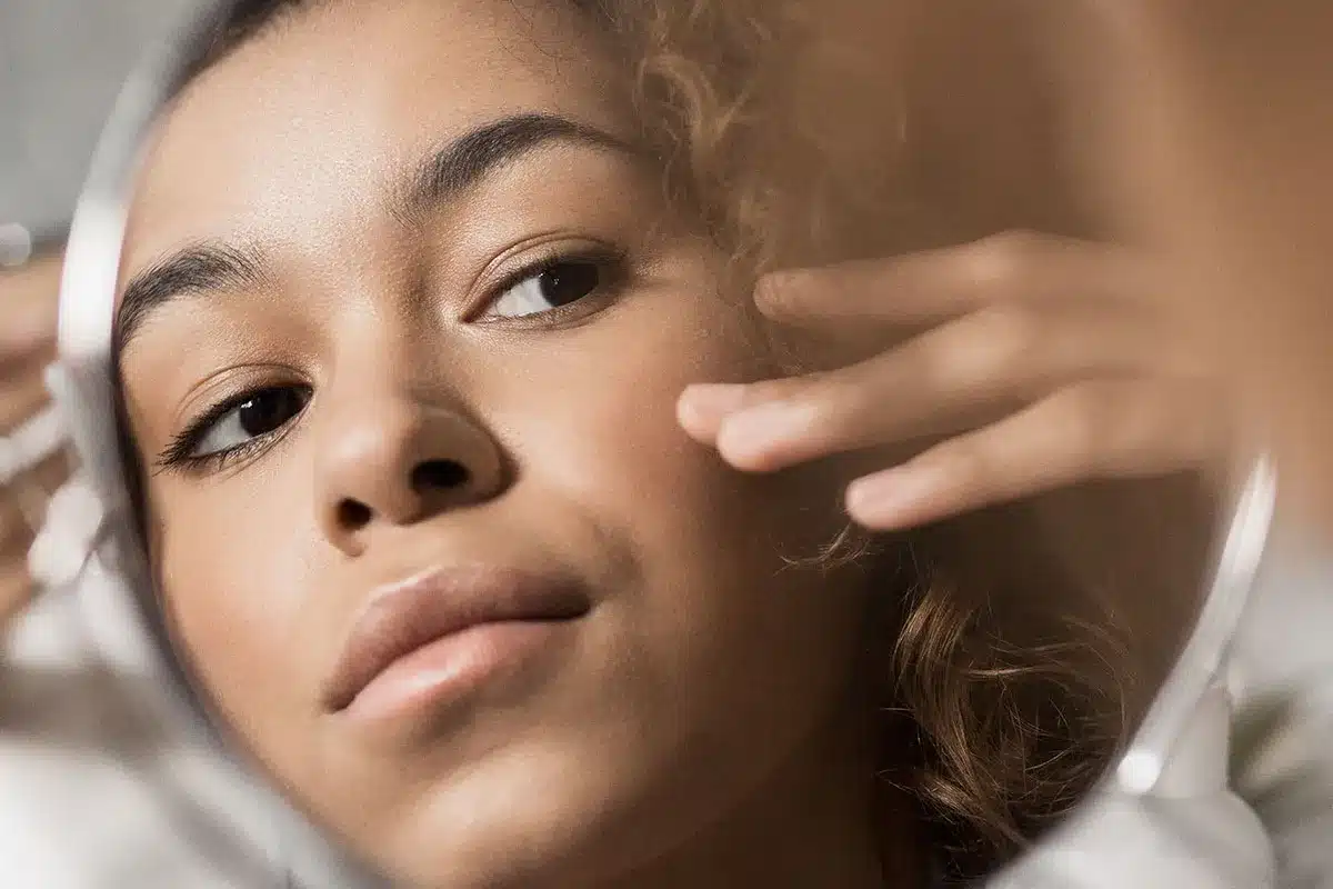 Woman looking at her reflection in mirror.