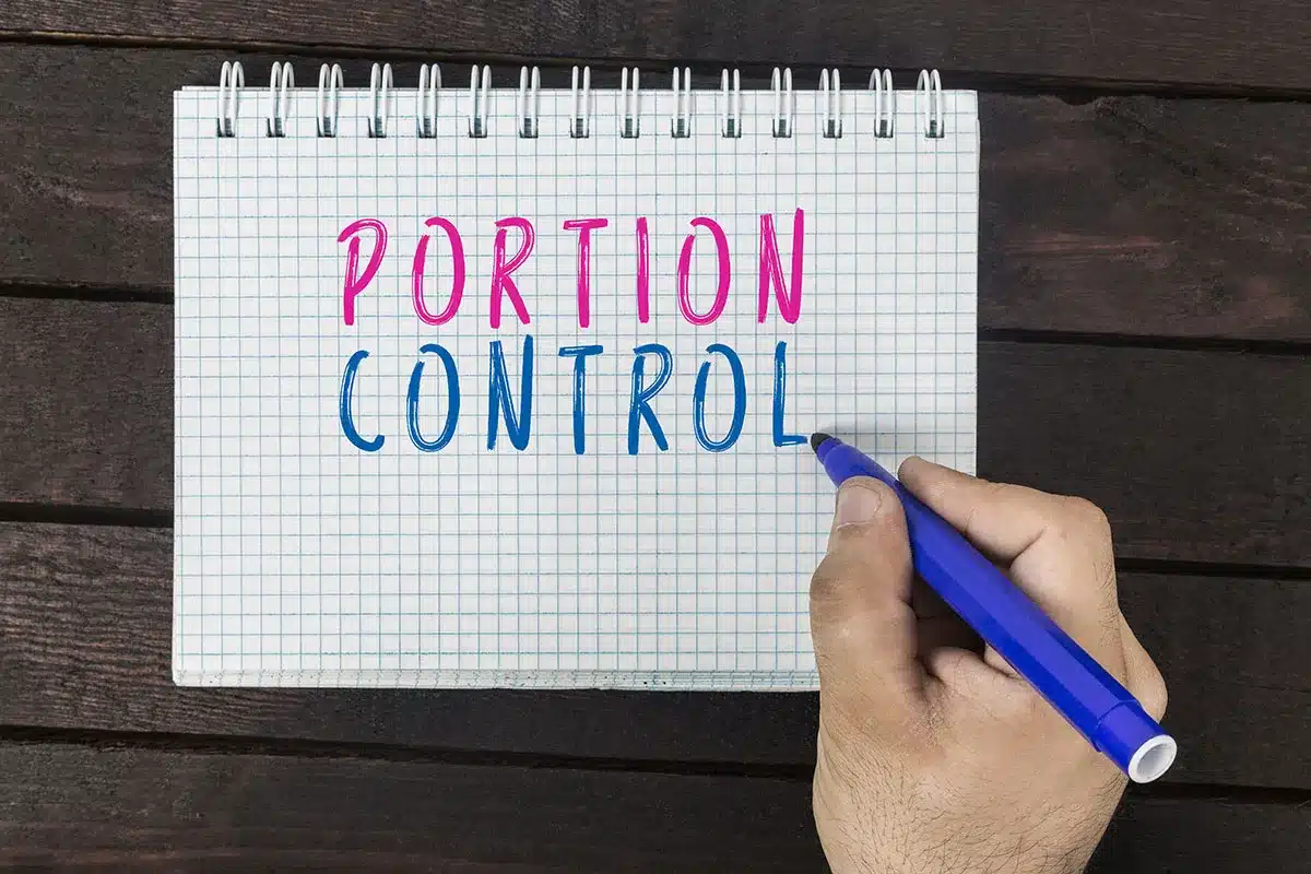 Hand writing "Portion Control" in notepad.