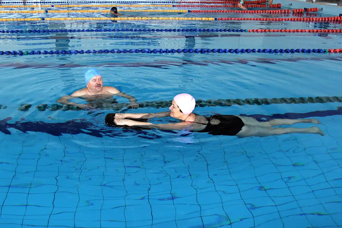 Older couple doing water aerobics.