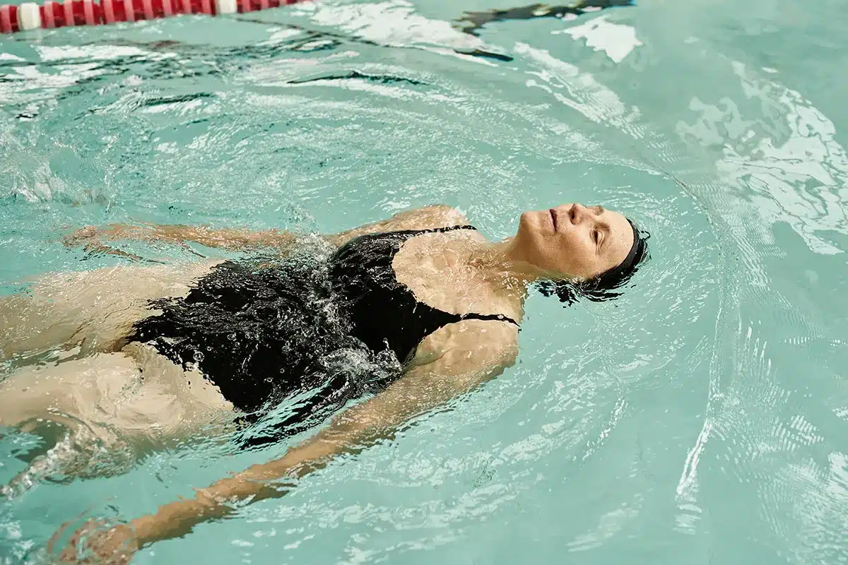 Plus-size woman swimming in a pool.