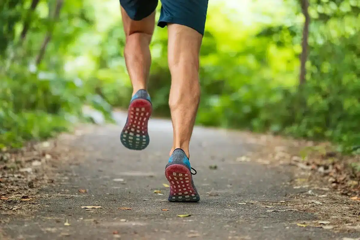 Man running on a trail outdoors.