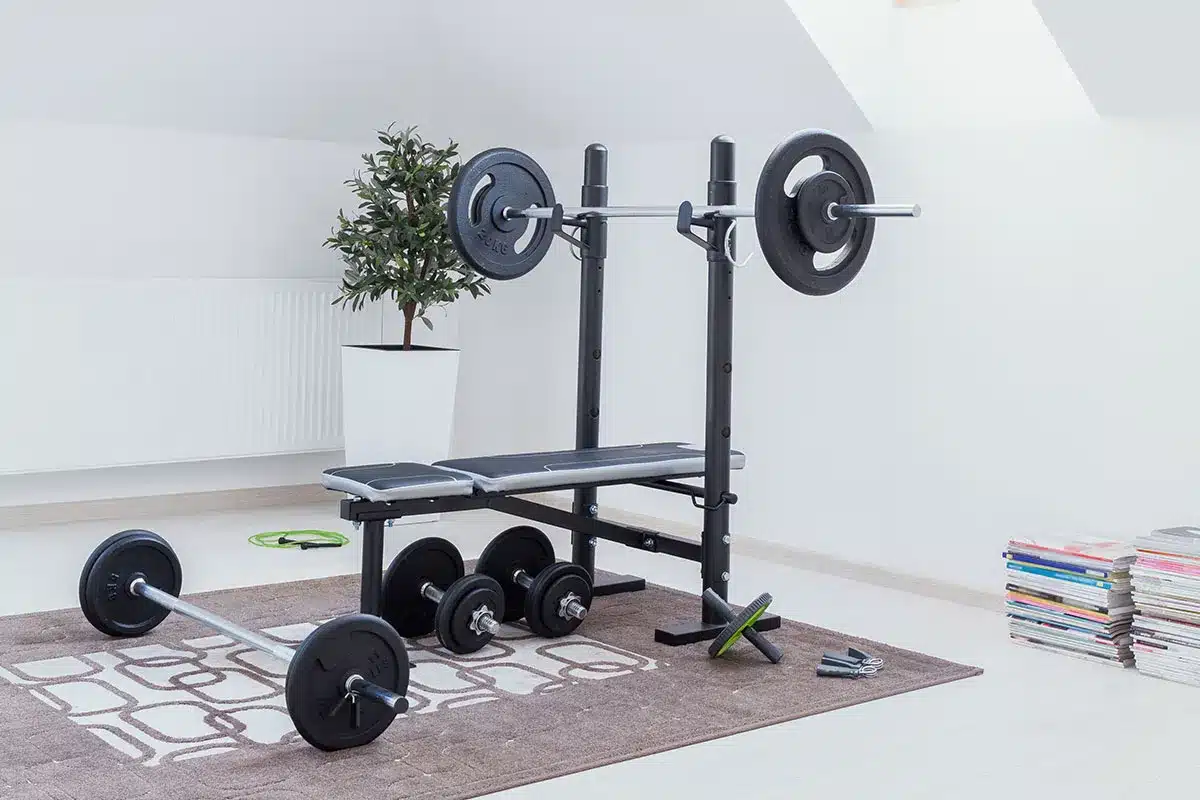 Home gym with weight bench and barbell.
