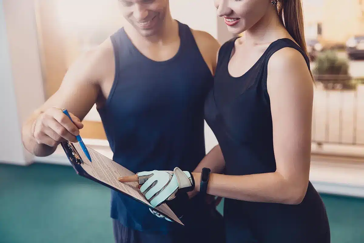 Personal trainer and client reviewing workout plan.