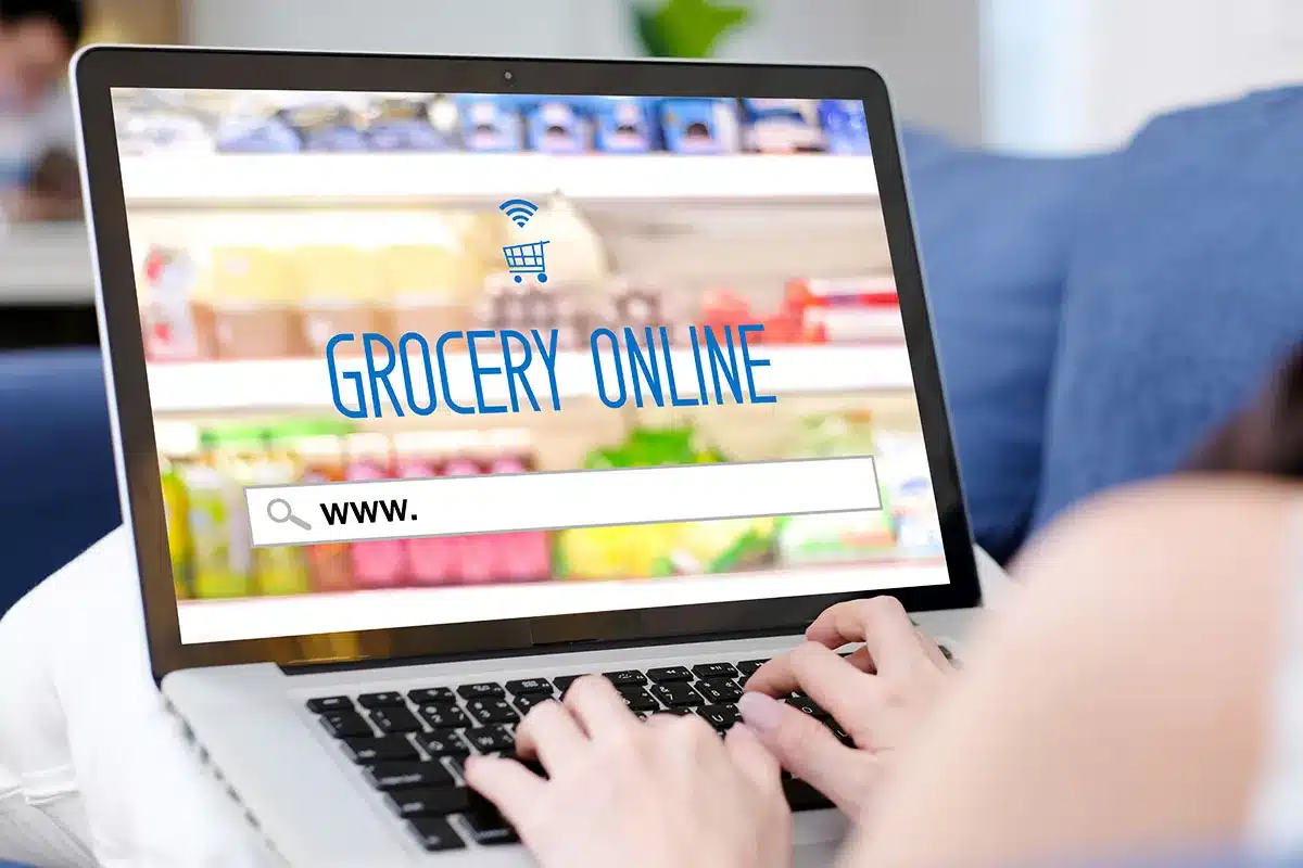Woman ordering groceries online on laptop.