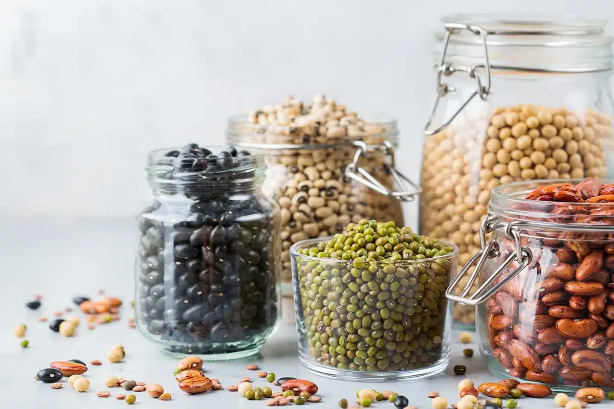 Assortment of dried beans and lentils in jars.