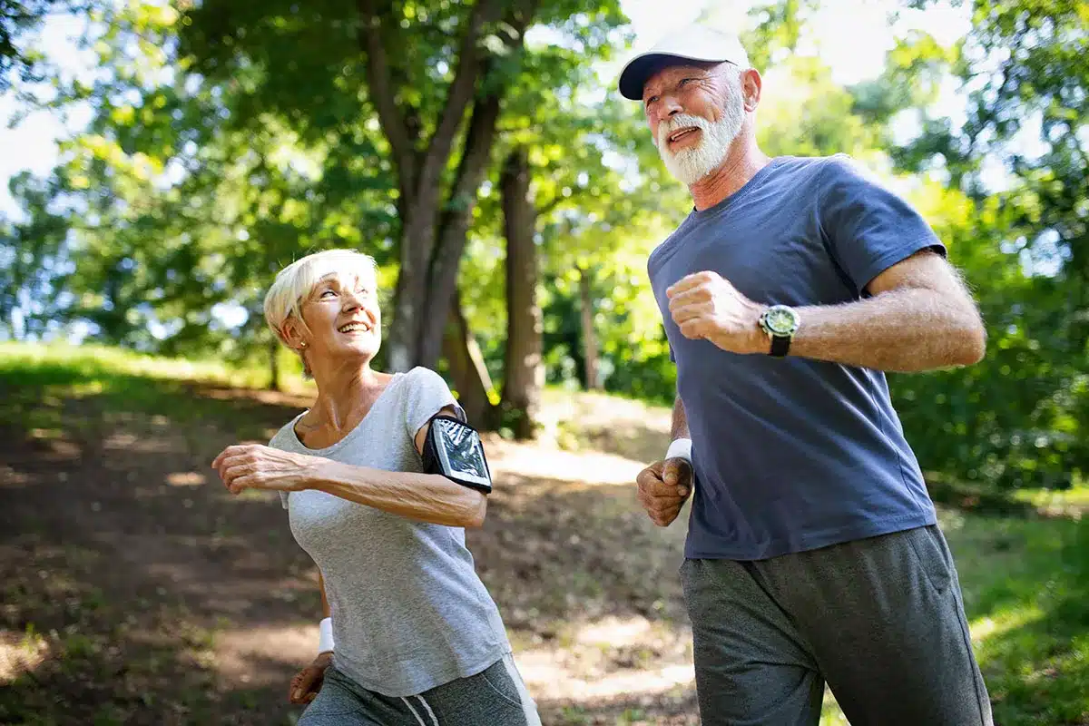 Active senior couple jogging outdoors.
